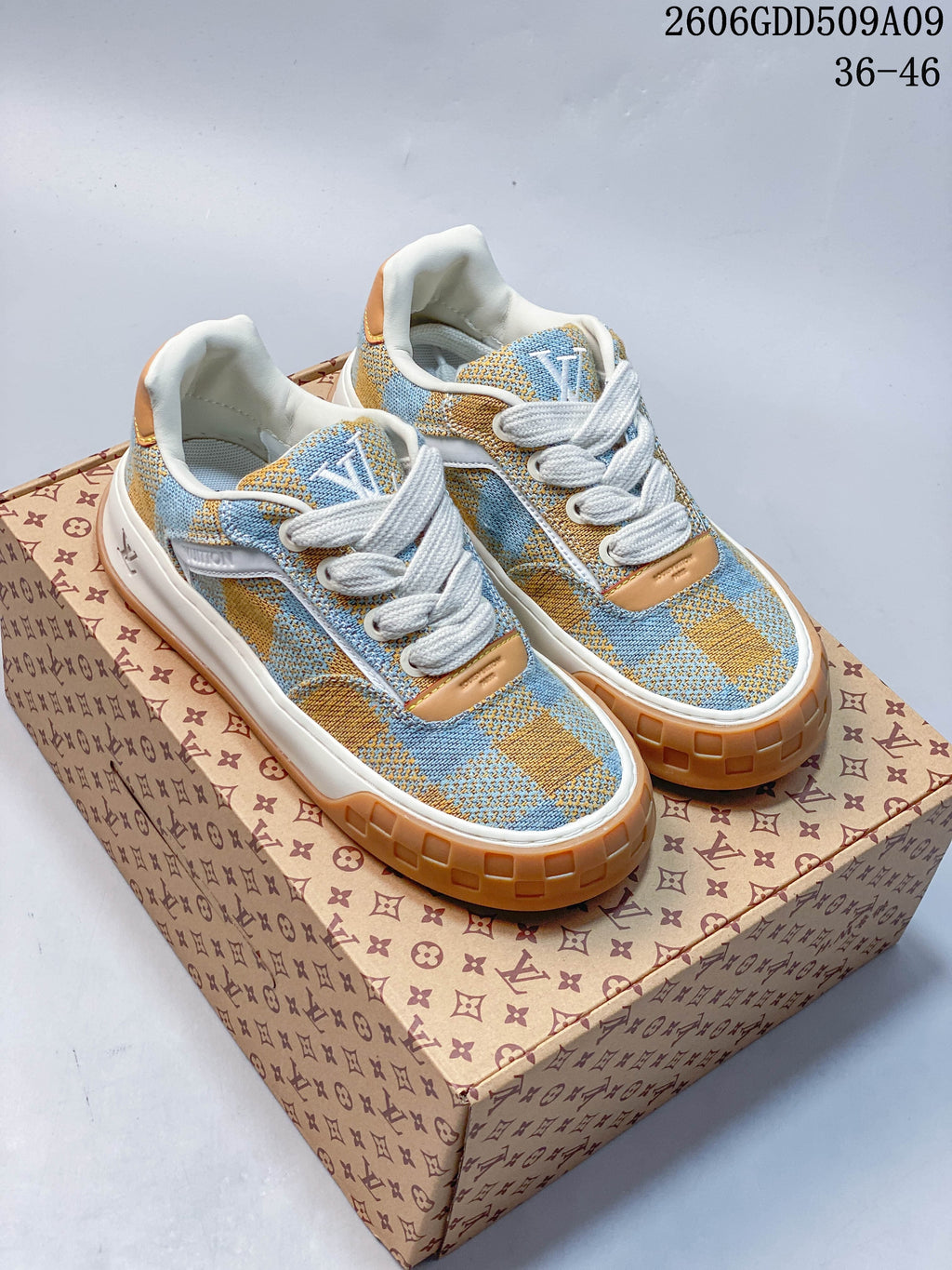 Pair of blue and tan check-patterned low-top sneakers with white laces and tan outsole accents.