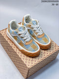 Pair of blue and tan check-patterned low-top sneakers with white laces and tan outsole accents.