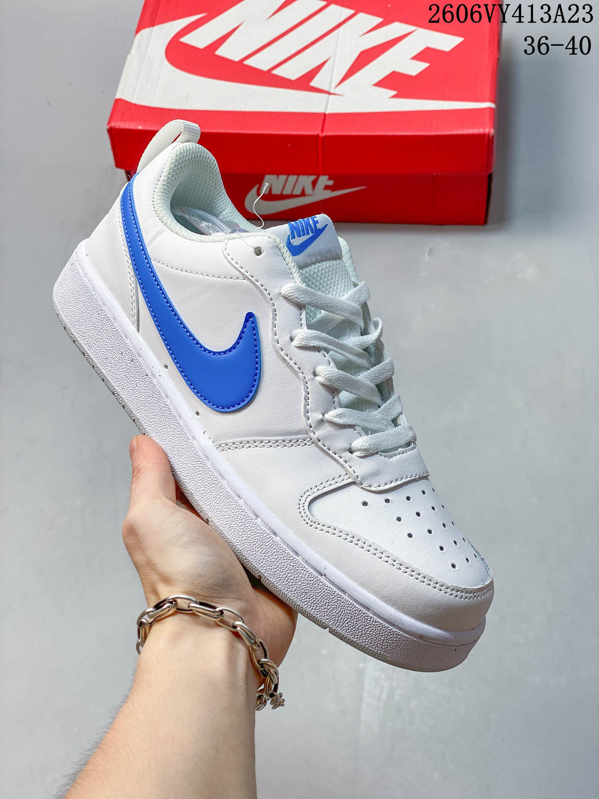 White low-top sneaker with a bright blue Swoosh and perforated toe