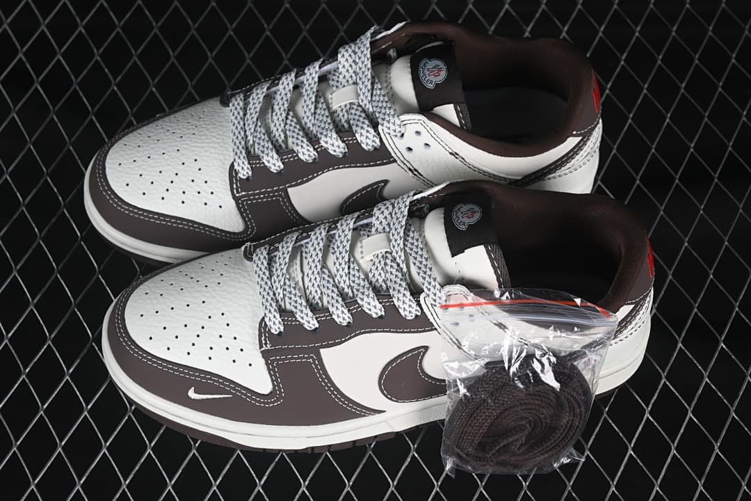 Pair of cream and brown low-top sneakers with patterned laces and a spare pair of dark laces
