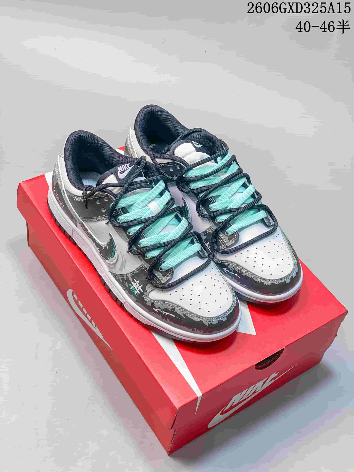 Pair of gray and white Nike Dunk Low-style sneakers with aqua and dark laces on a red box