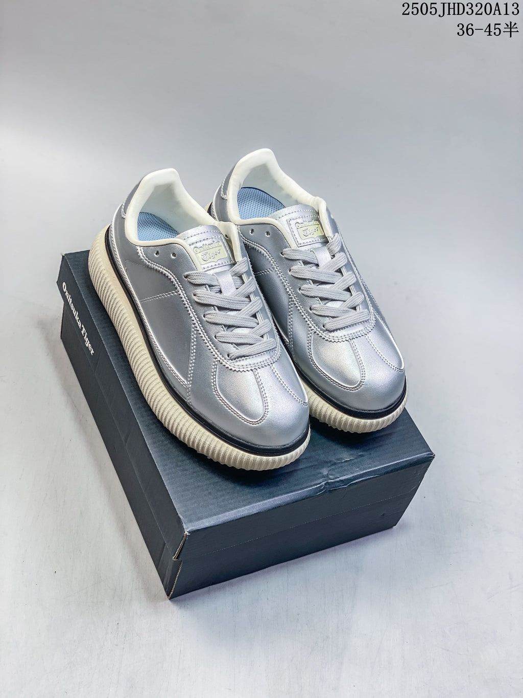 Pair of silver Onitsuka Tiger Delecity low-top sneakers on a shoebox