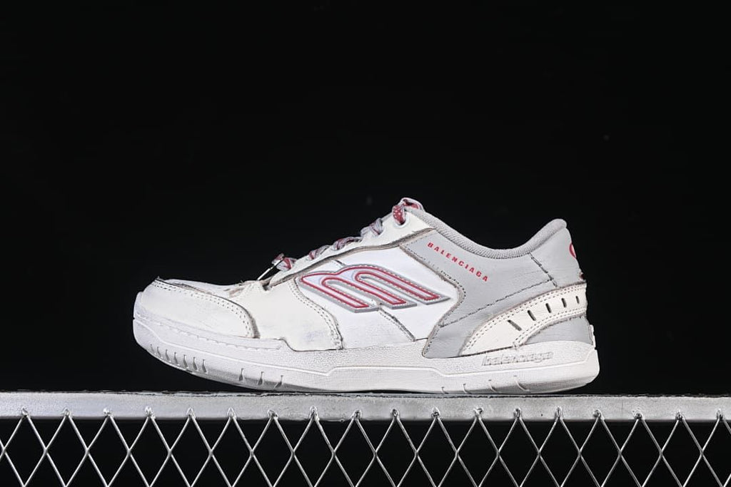 Side view of an off-white and grey Balenciaga Hamptons sneaker with red accents
