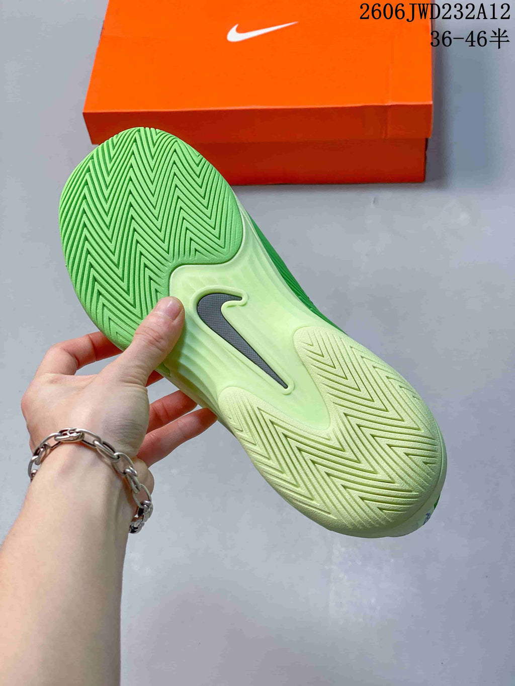 Close-up of the patterned outsole on a green and pale cream tennis shoe