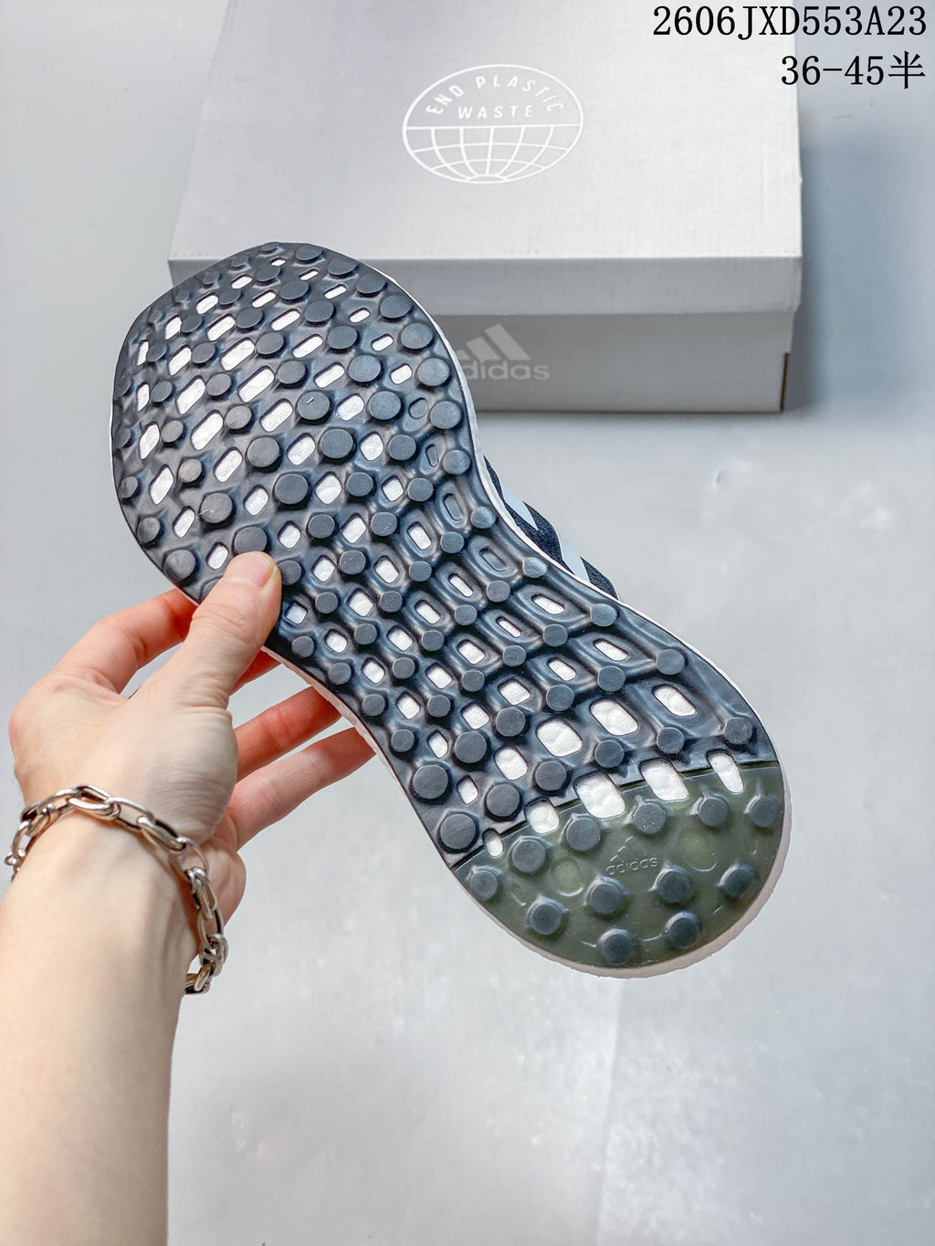 Close-up of the patterned outsole on a navy Adidas PureBoost 21 shoe.