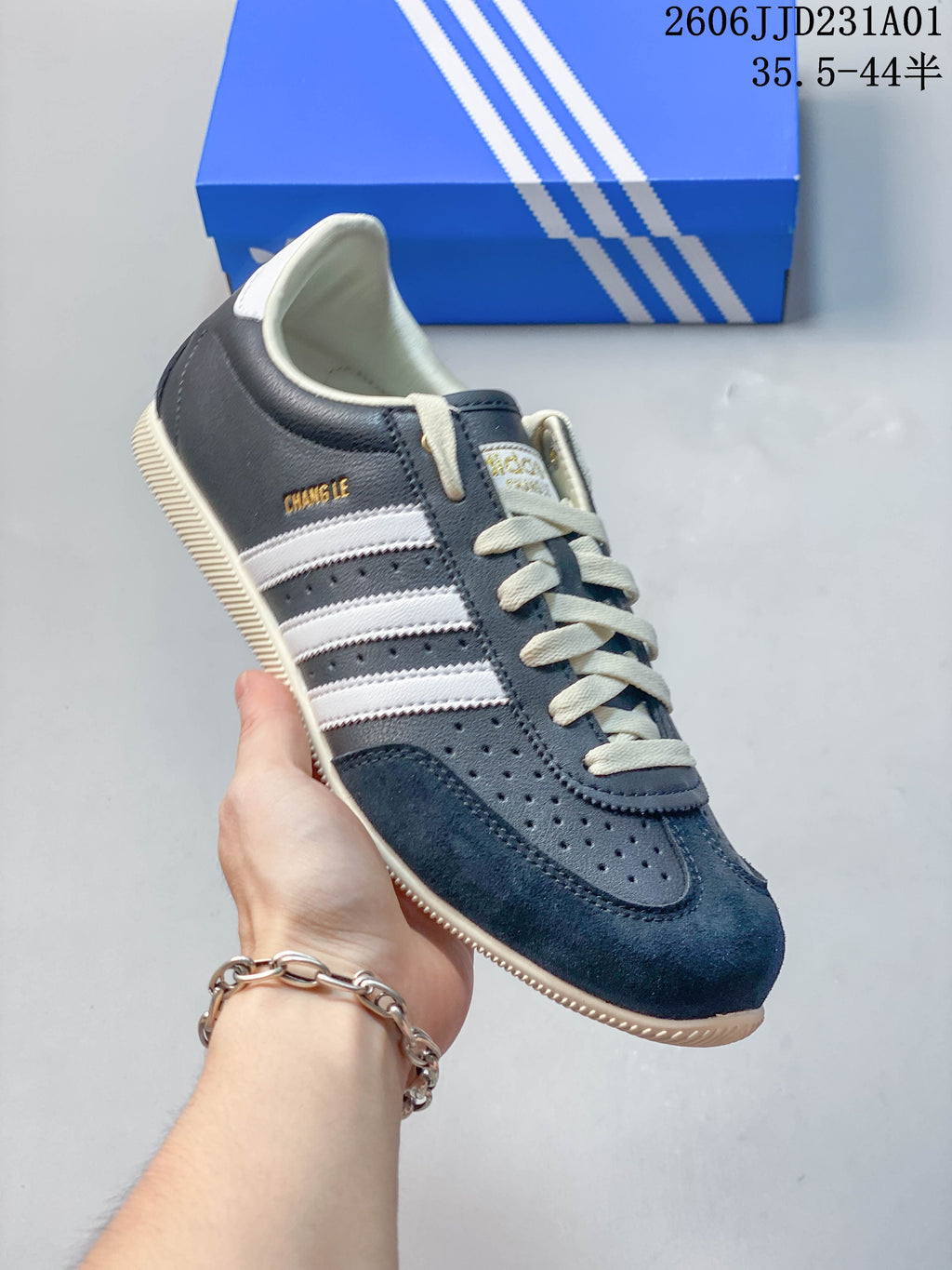 Angled view of the navy Changle sneaker with white stripes and a cream-colored sole