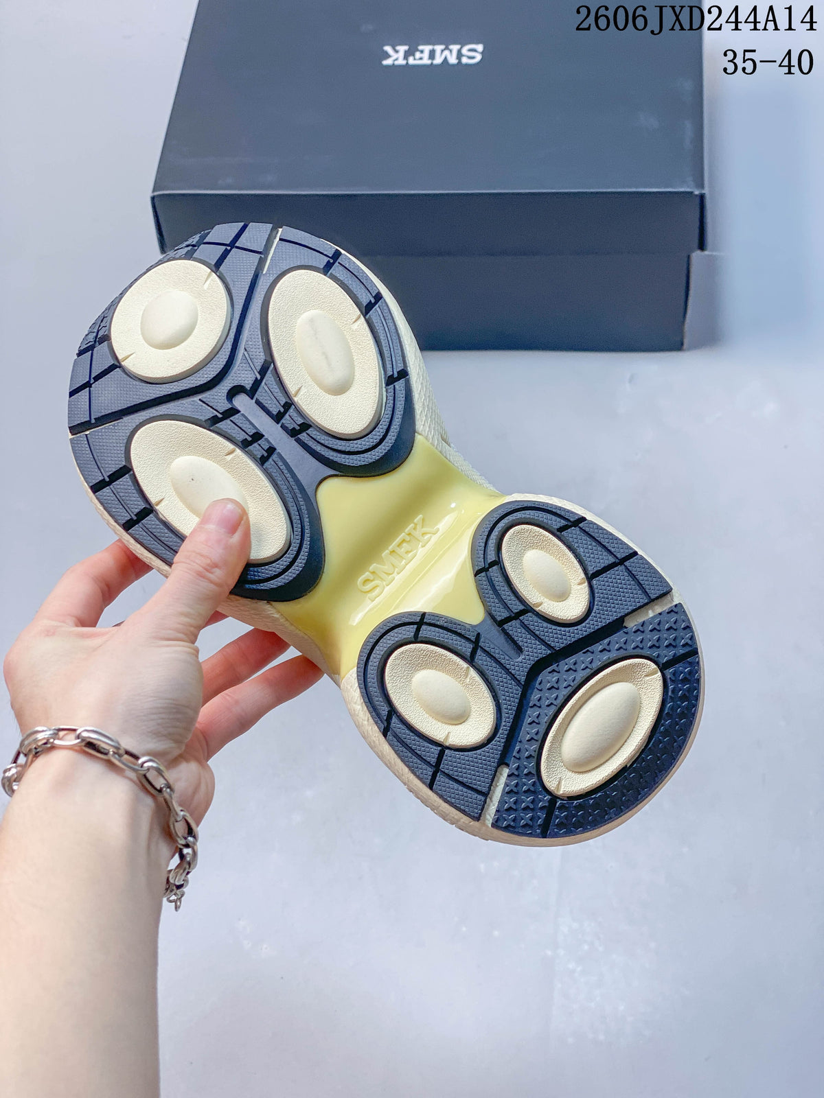Close-up of the sneaker outsole, showing segmented navy and cream tread.