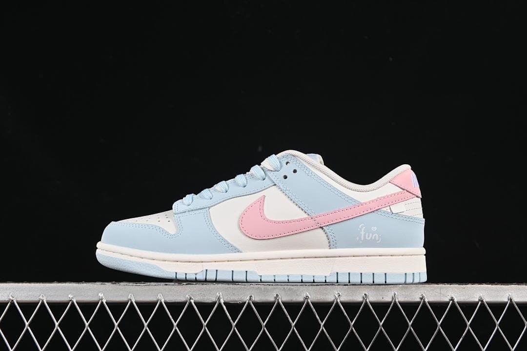 Side view of pale blue, white and pink Nike SB Dunk Low sneakers