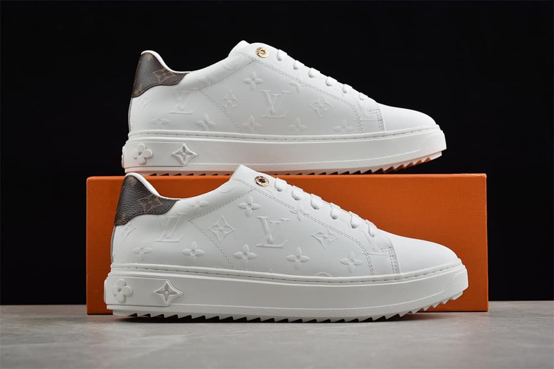 Two white platform sneakers displayed against an orange shoe box