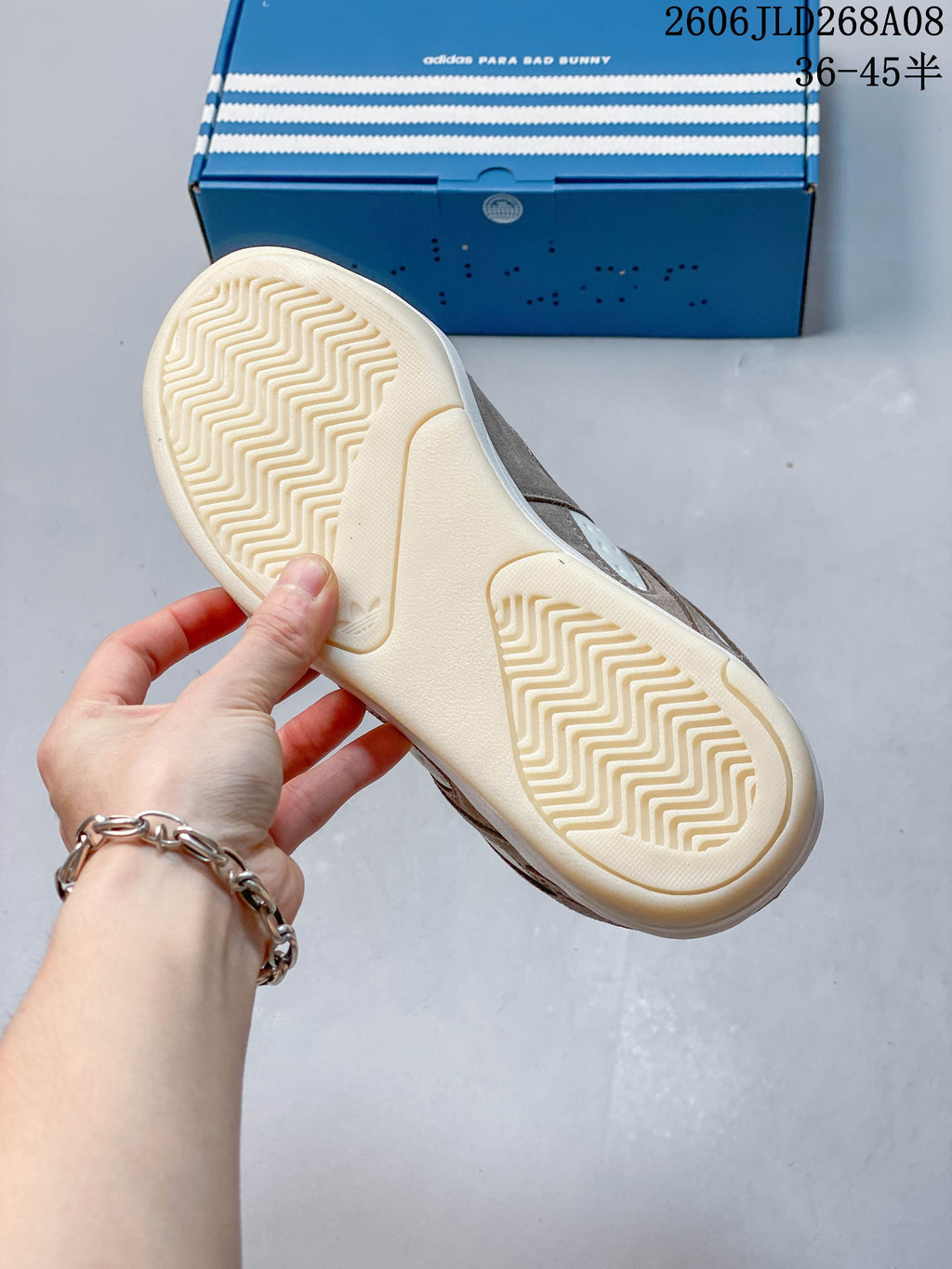 Close-up of the cream patterned outsole on a taupe and cream sneaker