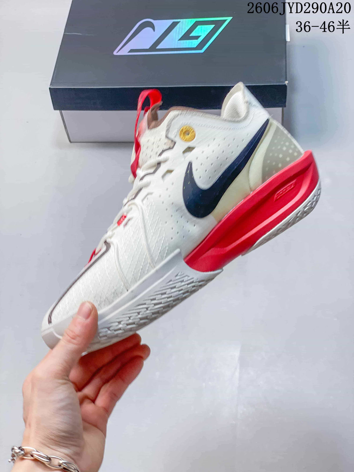 Side view of the white basketball shoe with dark Swoosh and red midsole accents