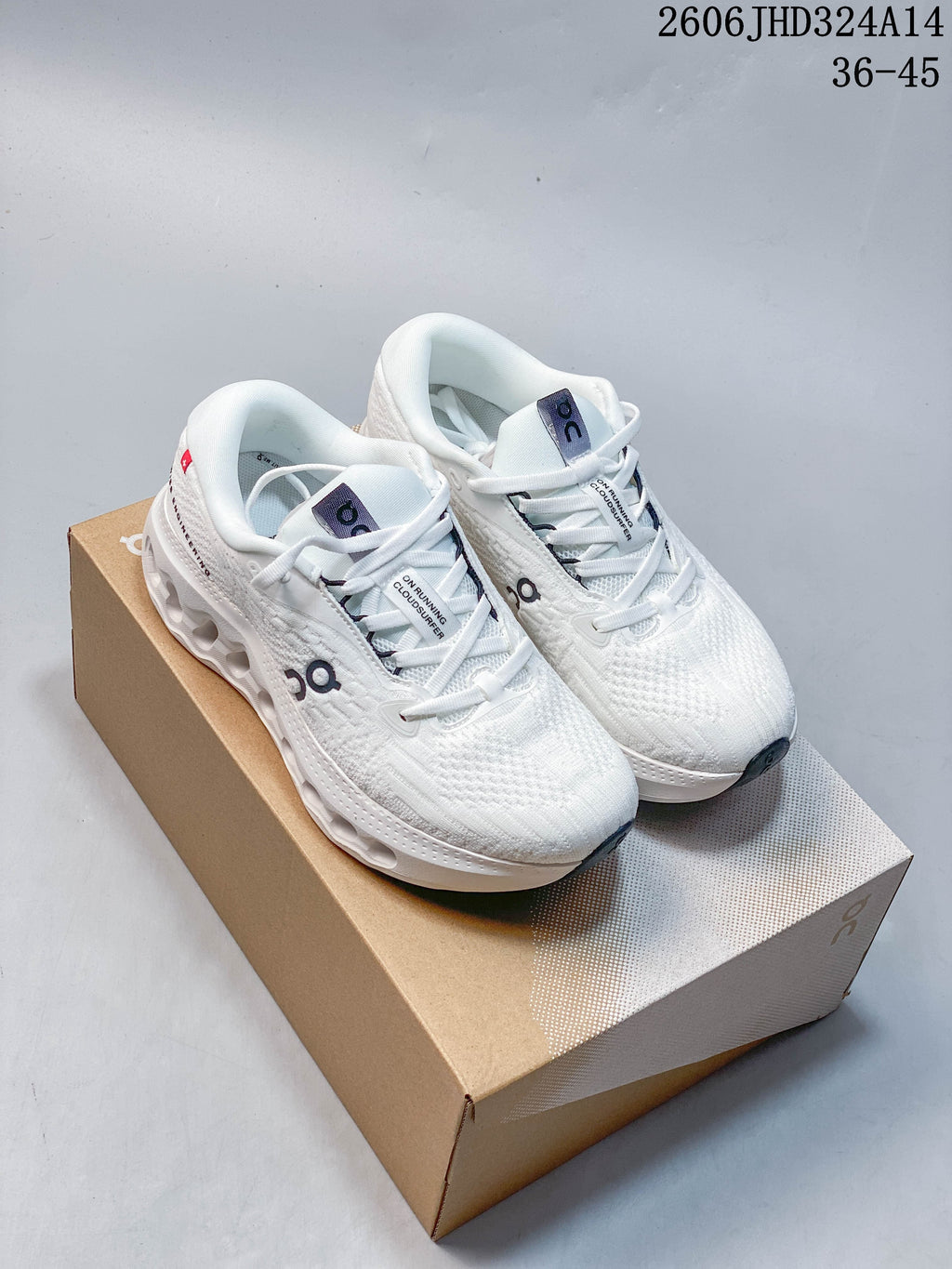 Pair of white On Cloudtilt shoes with dark logo details
