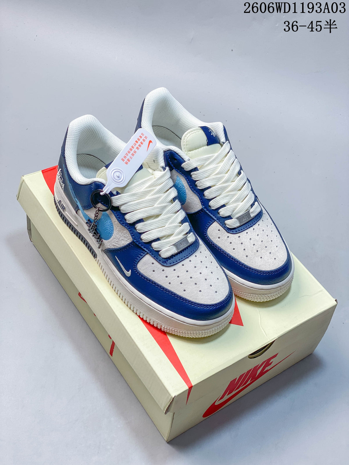 Pair of blue, gray, and off-white low-top sneakers displayed on a shoe box