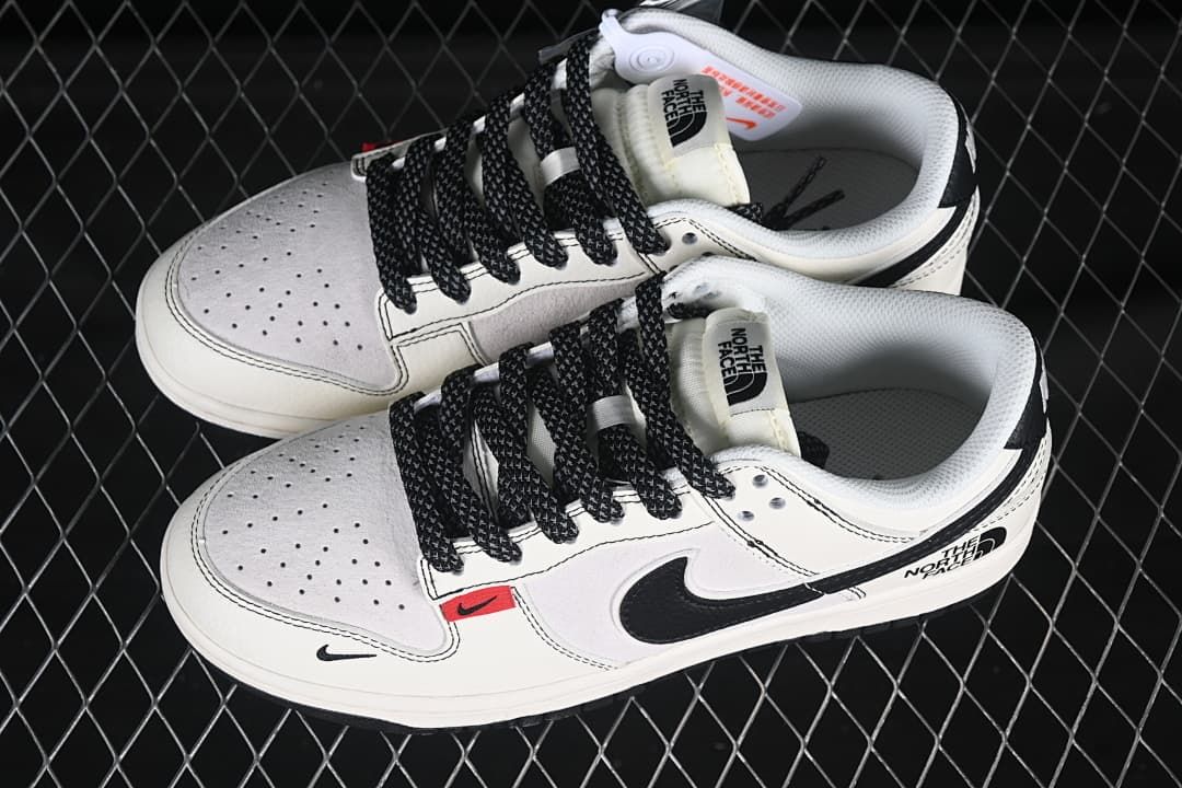 Overhead view of a pair of off-white and black low-top sneakers with black laces and The North Face tongue labels