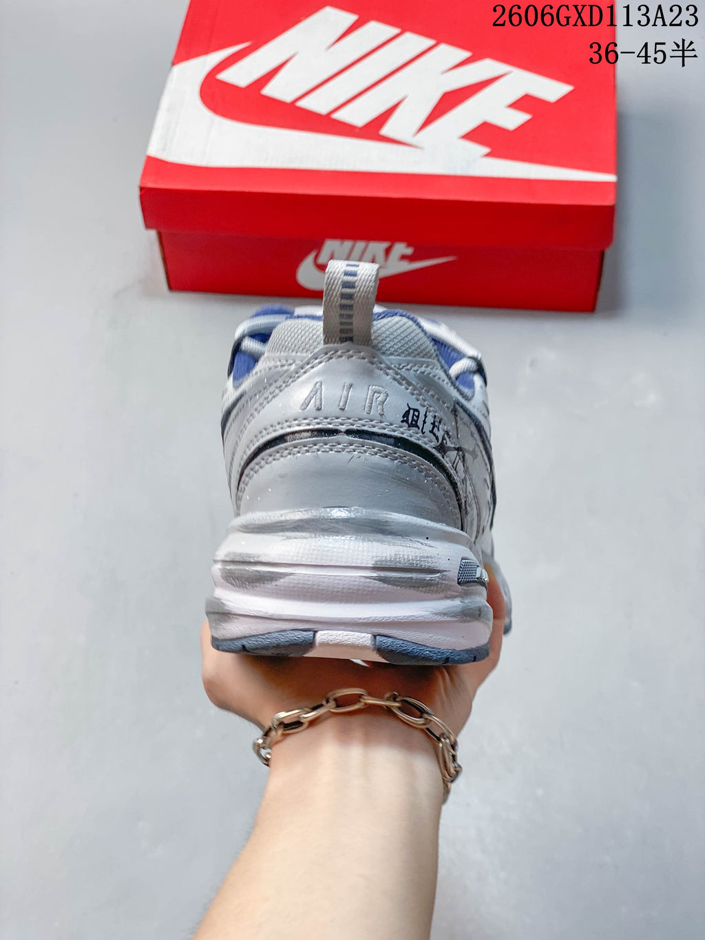 Rear view of the silver-toned sneaker with a padded blue collar and chunky sole.