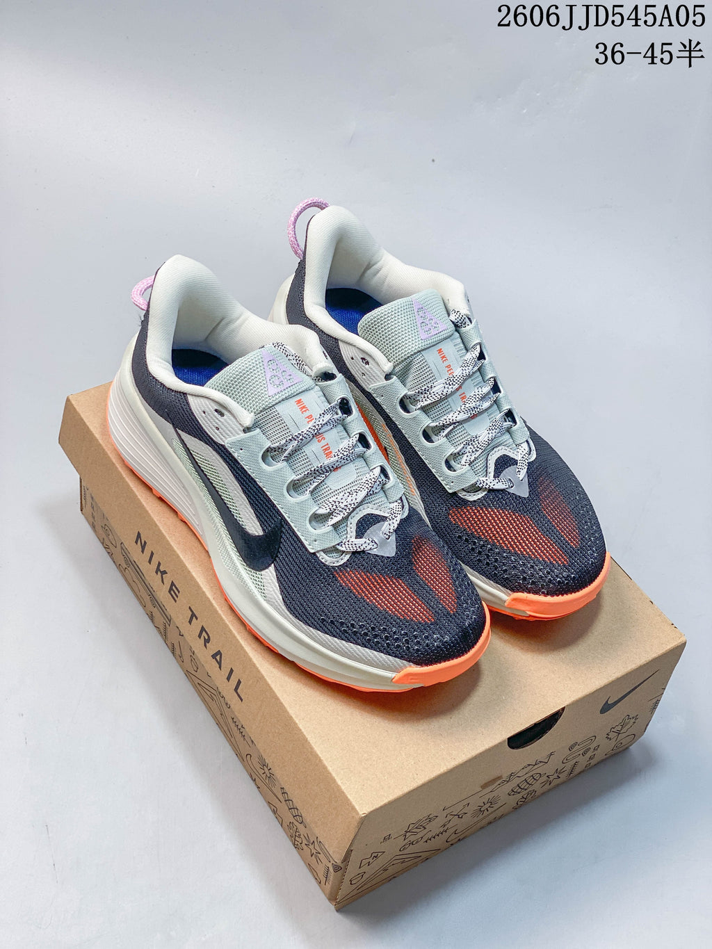 Navy Nike Pegasus Trail 6 shoes with orange and pale blue details on a box