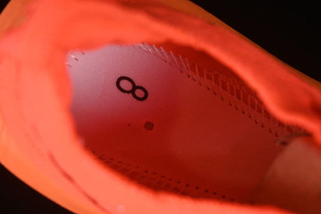 Close-up inside the orange shoe showing a printed size 8