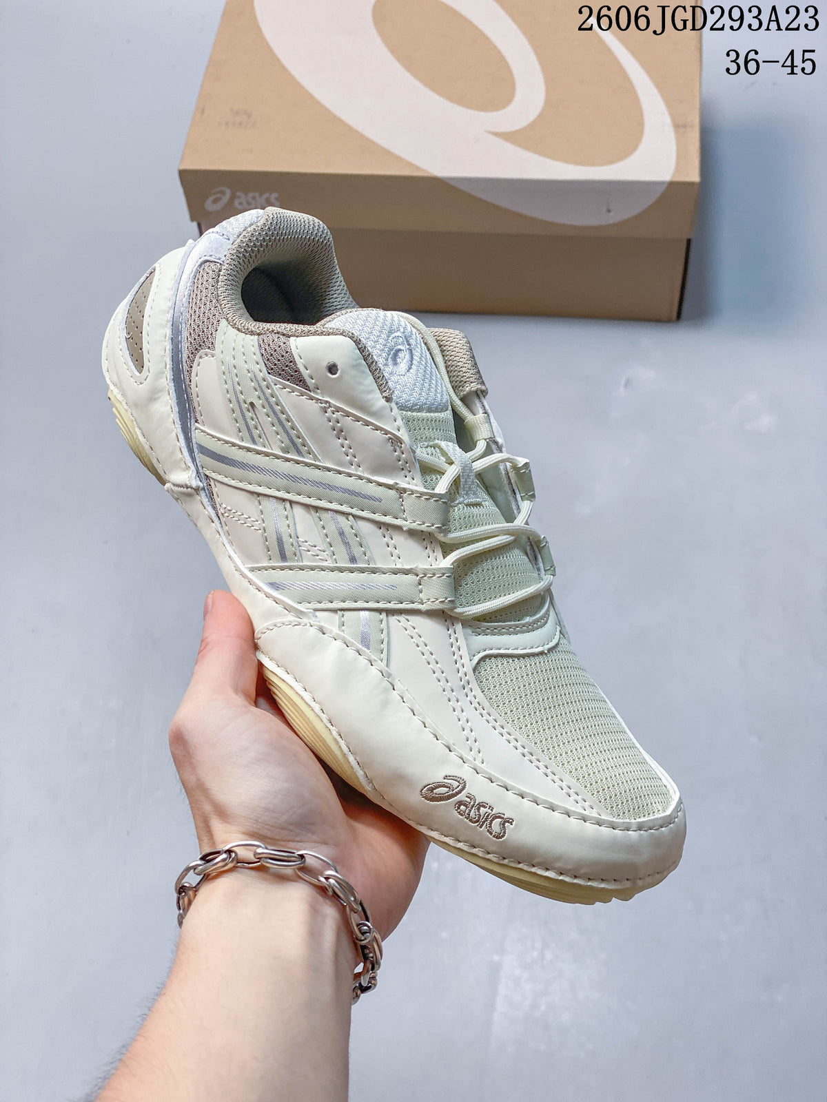 Off-white ASICS Gel-Pickax sneaker with pale gray-green mesh and layered side details.