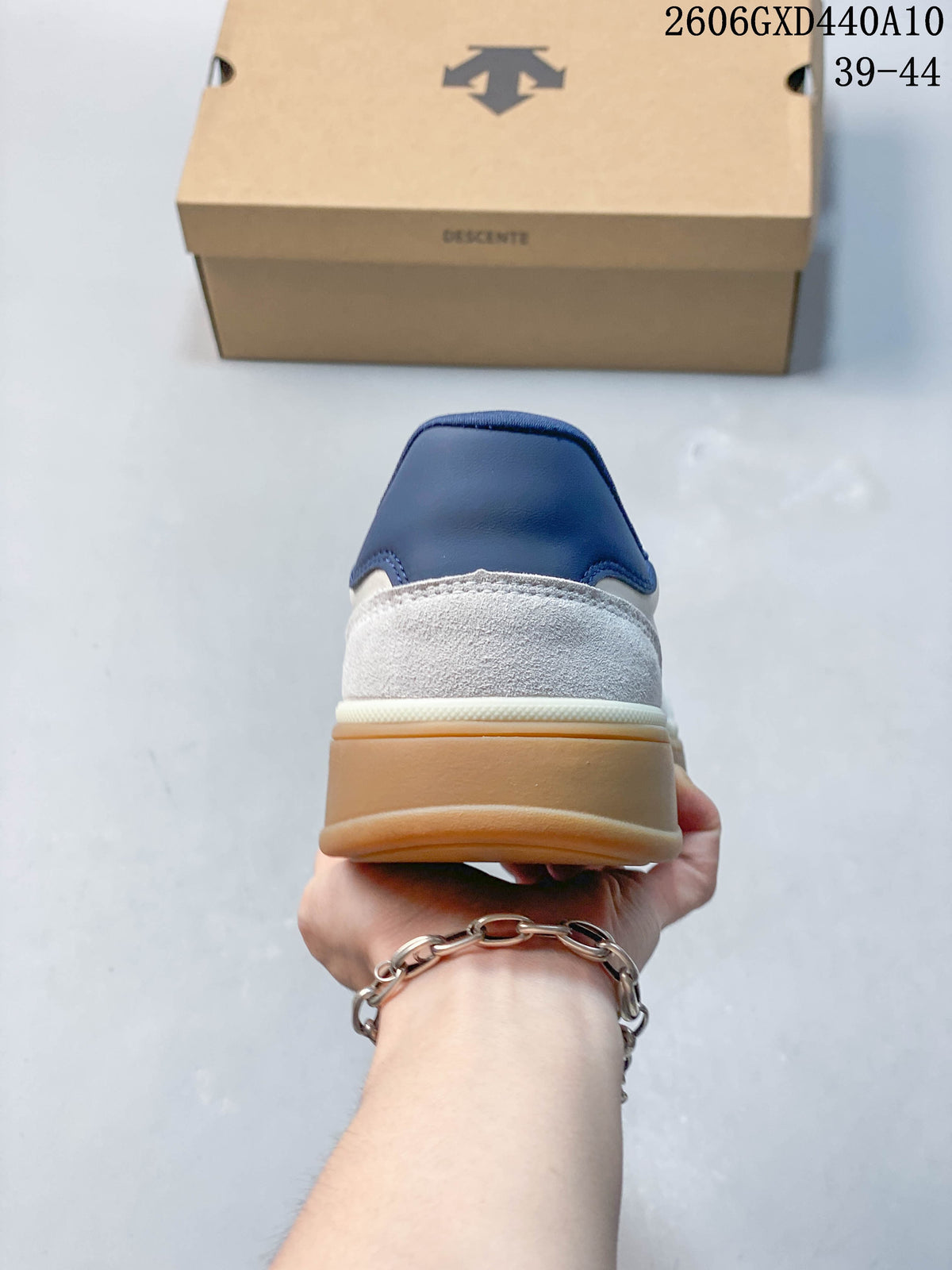 Rear view of the sneaker showing the navy heel tab, gray heel panel, and gum-colored sole.