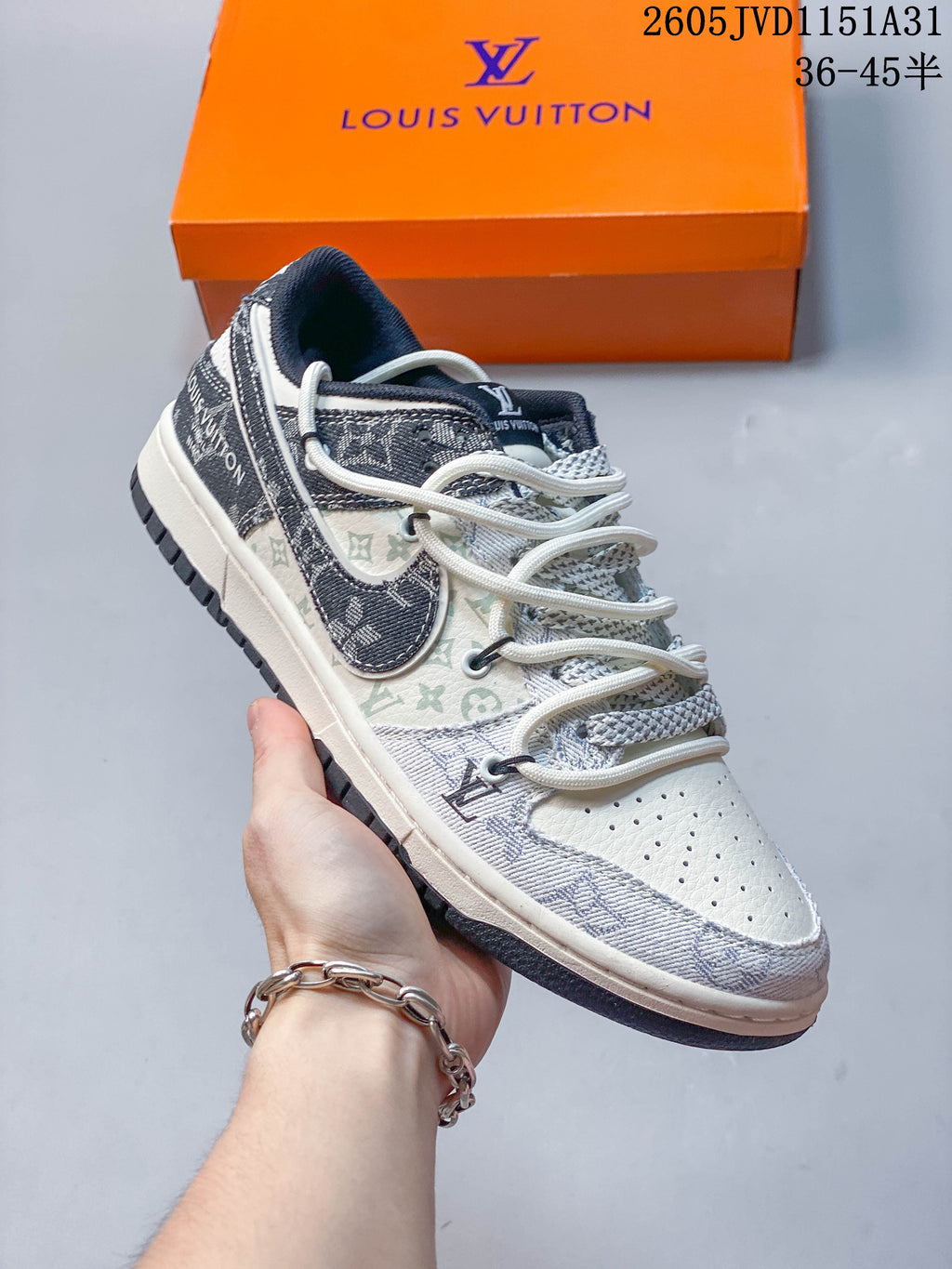 Close view of a cream sneaker with dark patterned side panels, a contrasting swoosh-shaped overlay, and layered laces.