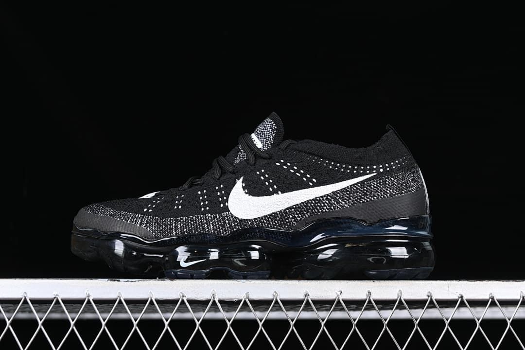 Side view of a black Nike Air Vapormax 2023 Flyknit with white Swoosh and visible air-cushioned sole