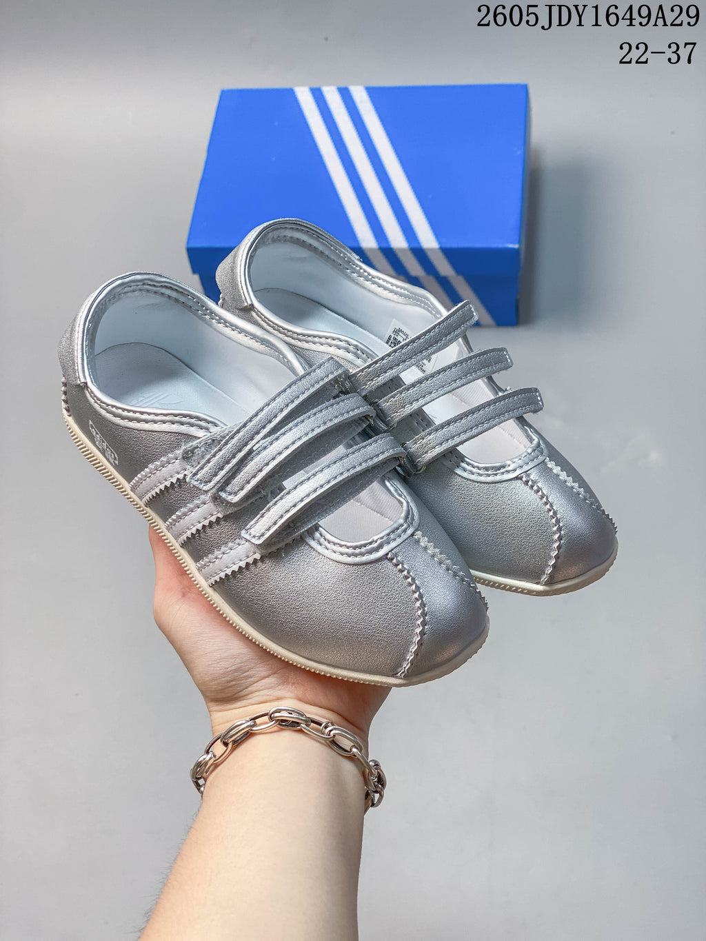 Pair of silver adidas-style sneakers with three hook-and-loop straps and light-colored soles