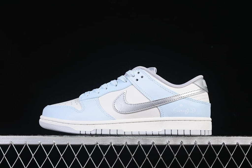 Side profile of a light blue, white, and silver low-top Nike Dunk sneaker
