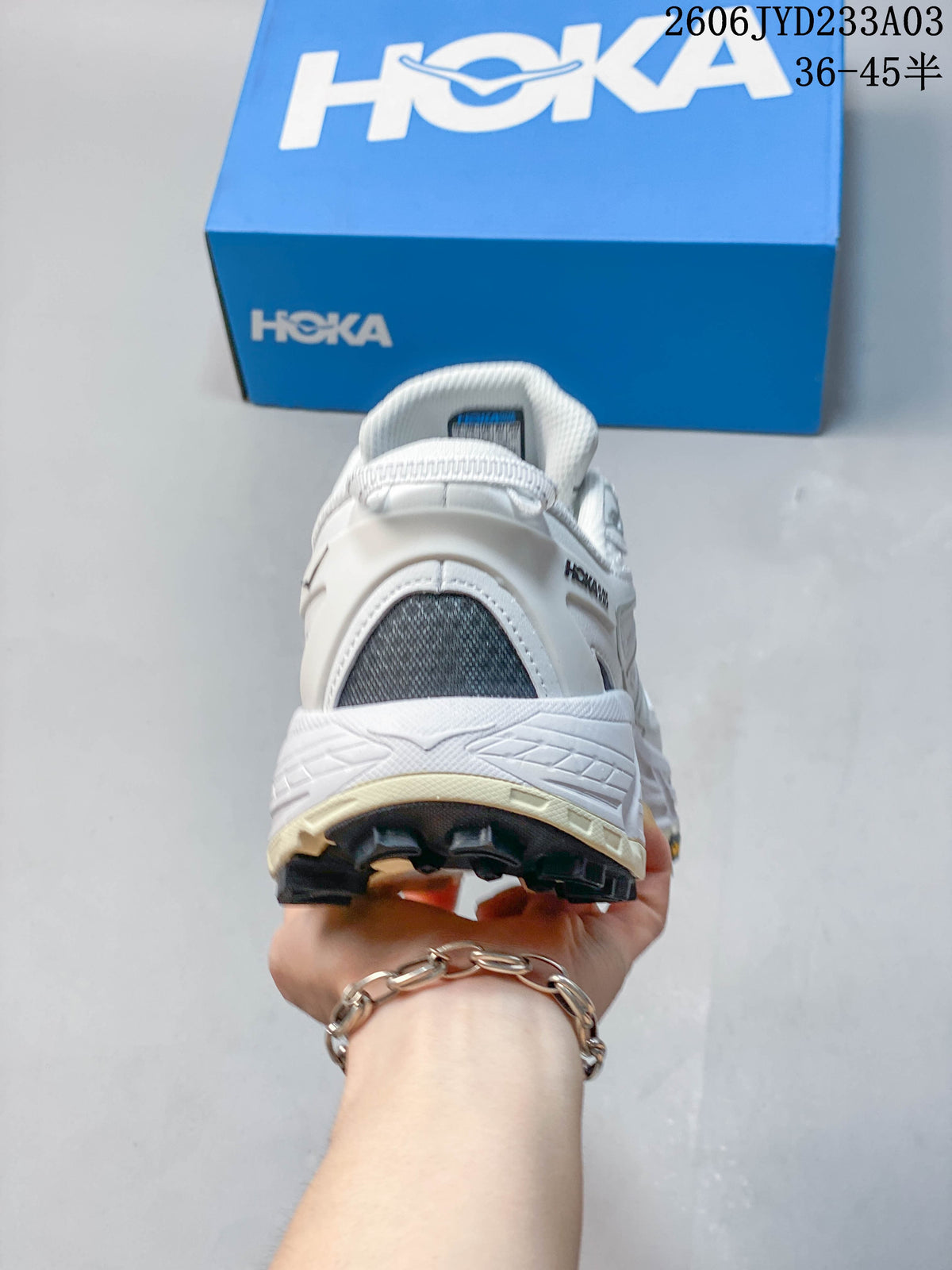 Rear view of a white HOKA trail shoe showing the heel and outsole