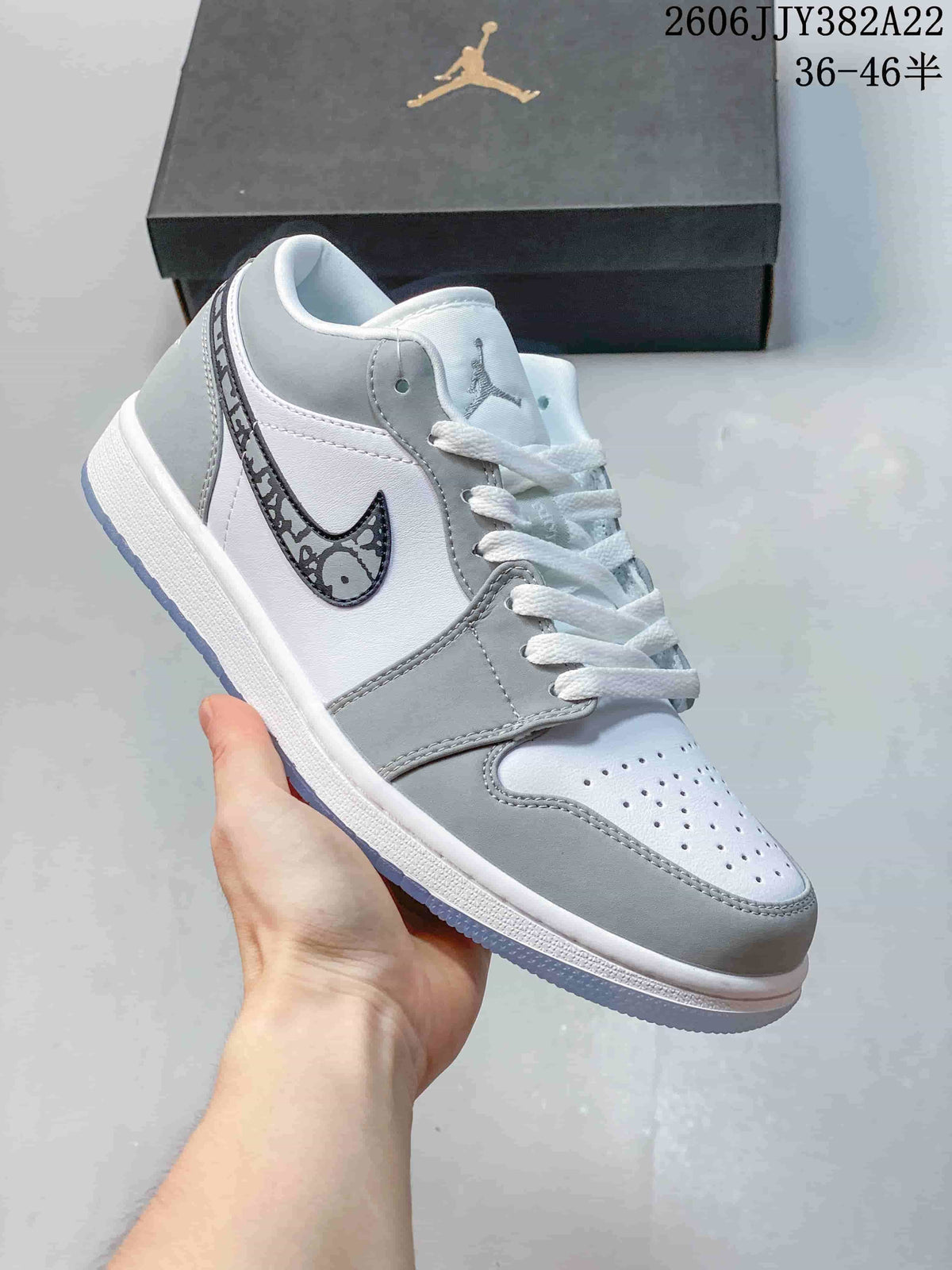 White and gray low-top sneaker with a patterned gray Swoosh and pale blue outsole.