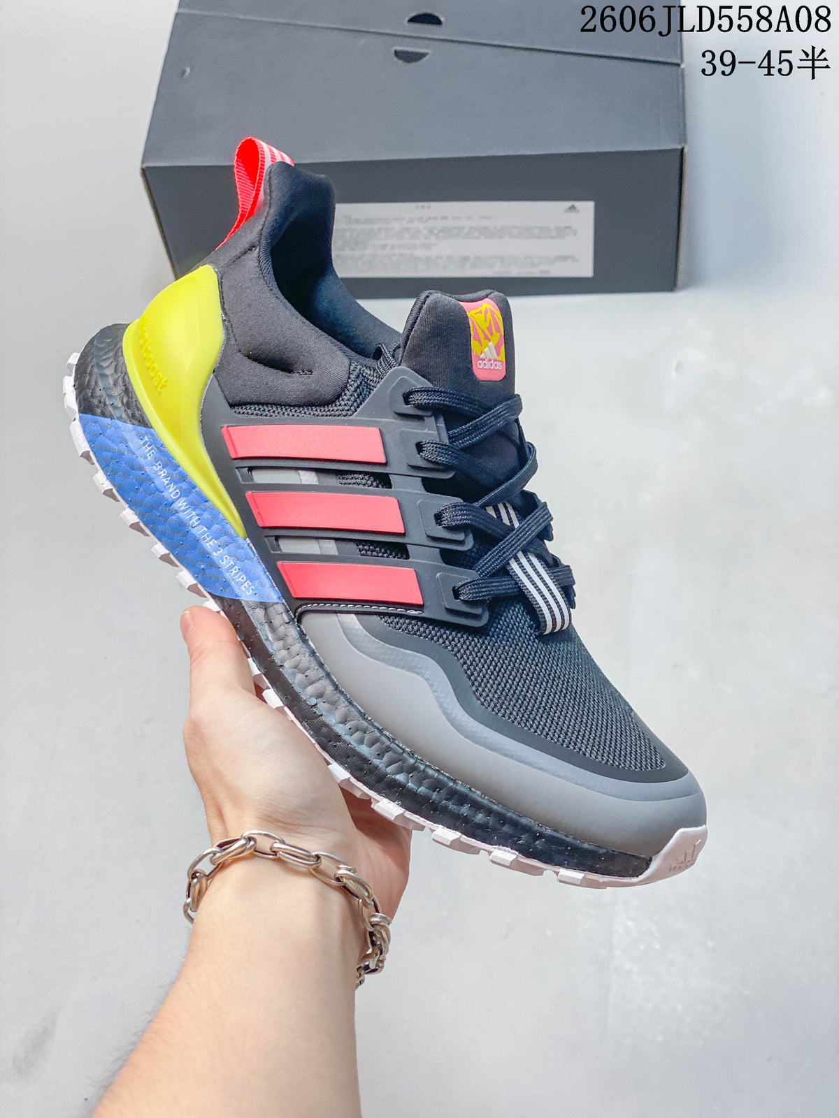 Side view showing the gray upper, coral-red stripes, neon yellow heel piece, and white outsole