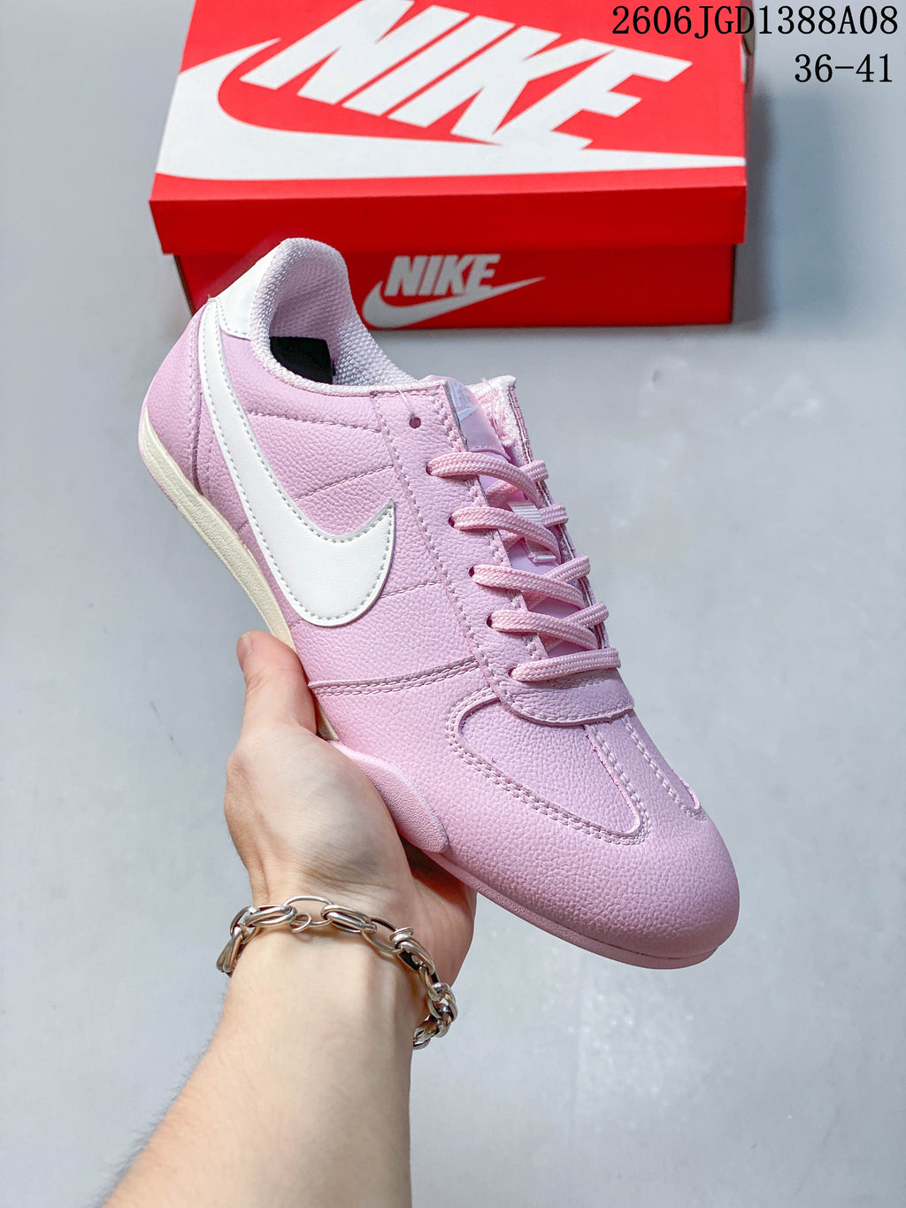 Angled side view of the pink sneaker with white Swoosh detail