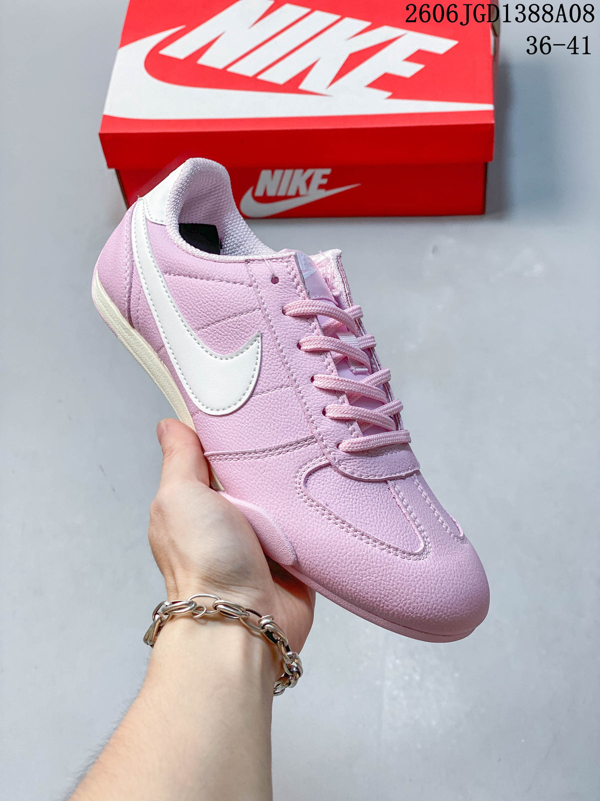 Angled side view of the pink sneaker with white Swoosh detail