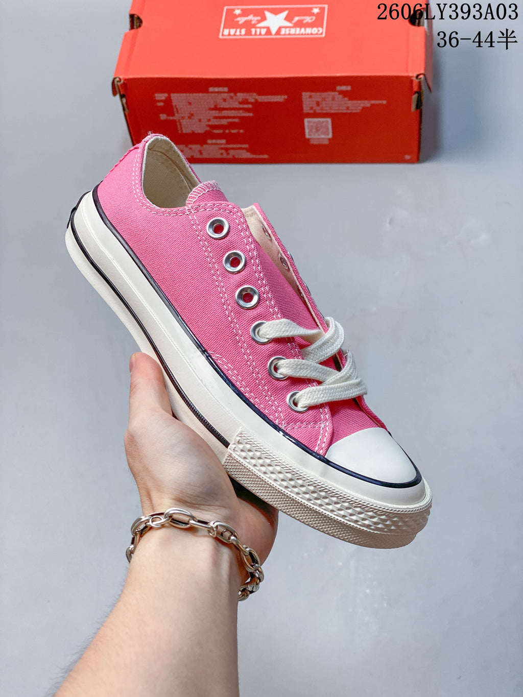 Bright pink low-top lace-up sneaker with an off-white sole and black stripe