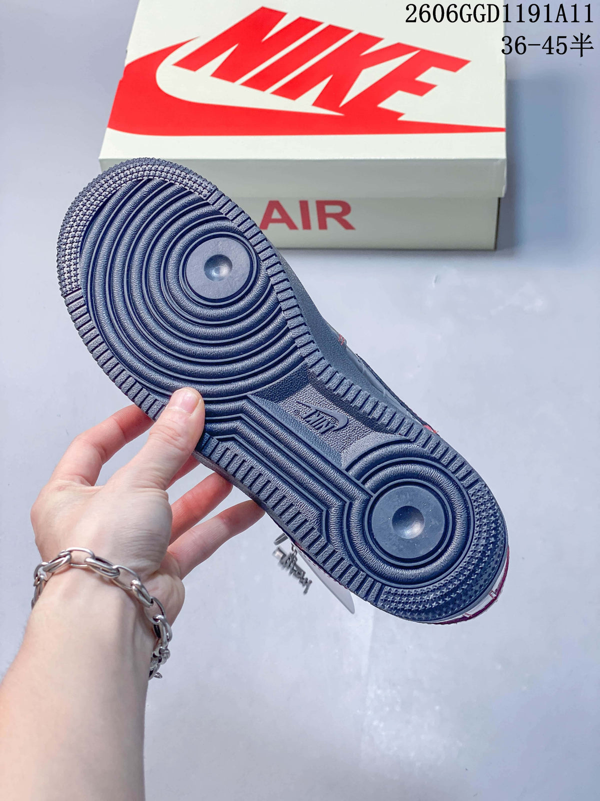 Outsole view of a dark low-top sneaker with circular tread details