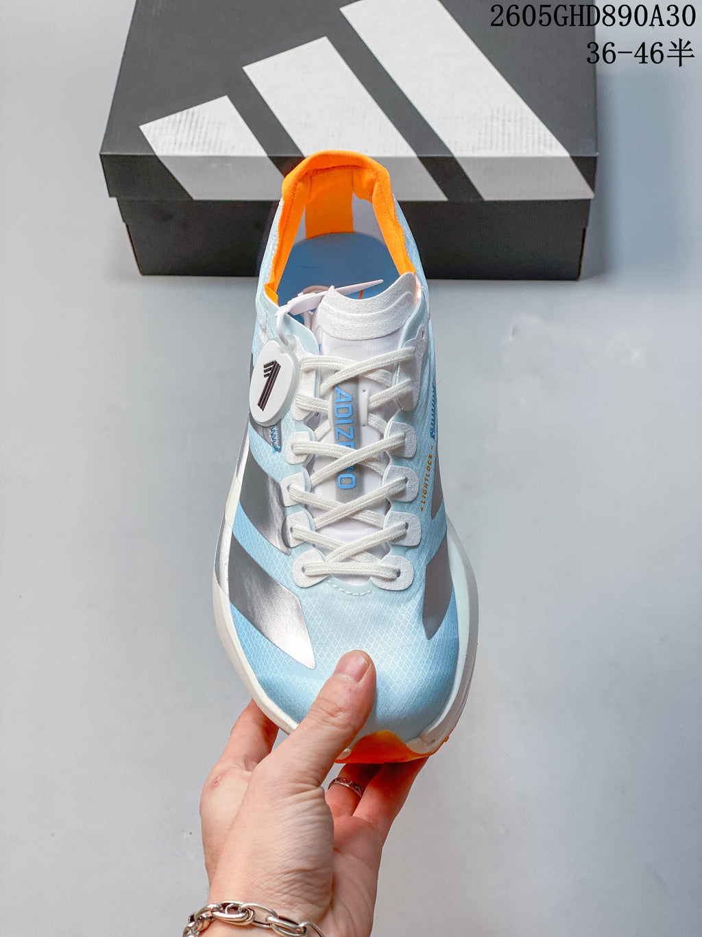 Front view of the shoe showing white laces and a pale blue upper