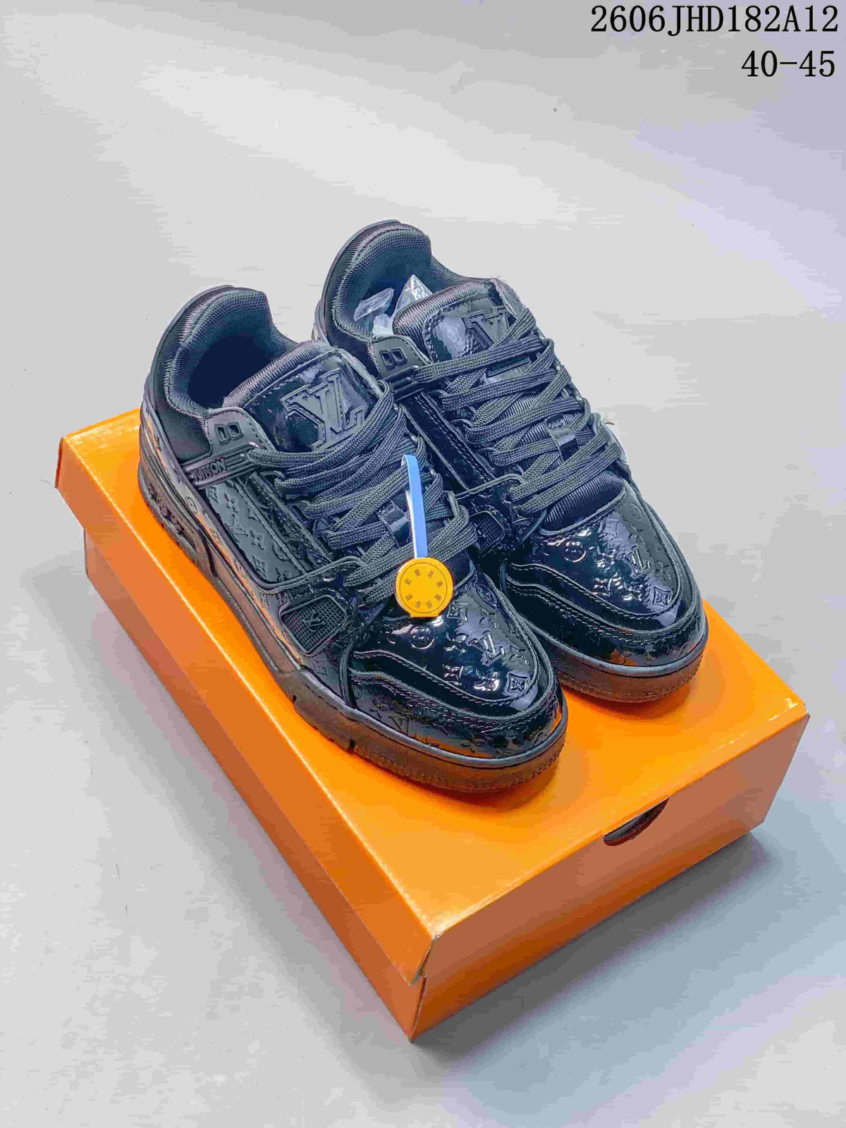 Pair of dark navy Louis Vuitton Trainer low-top sneakers on an orange box