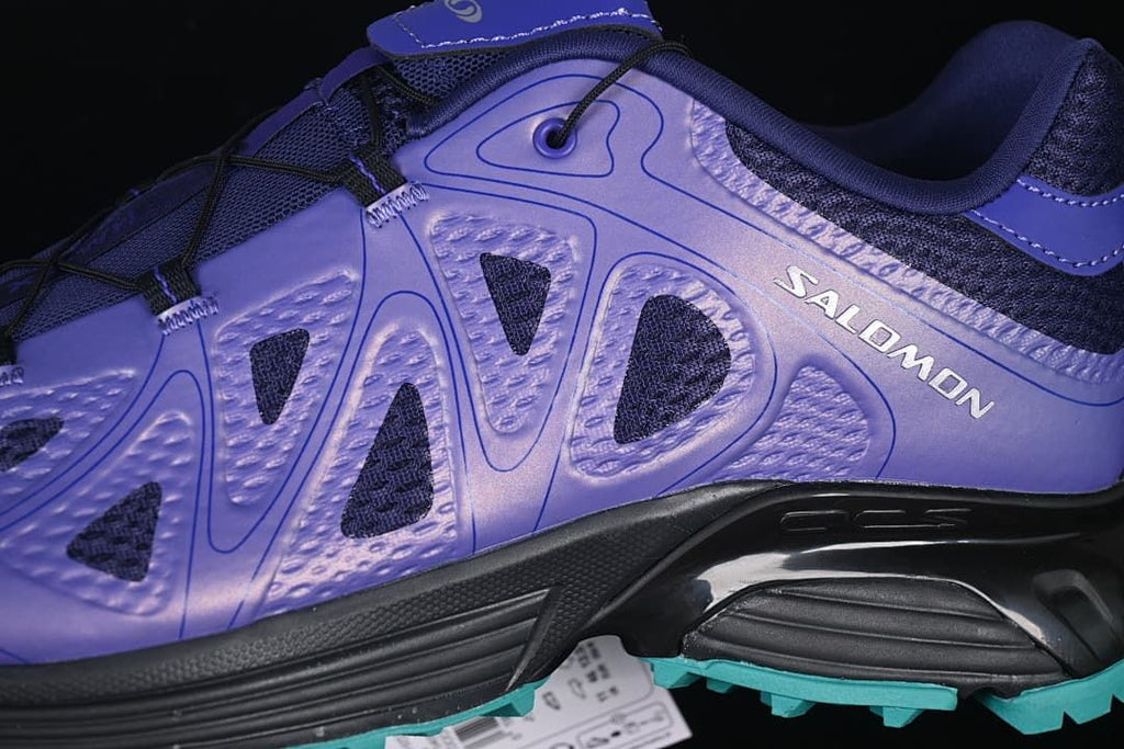 Close-up of geometric overlays, mesh panels, and the side of the sole.