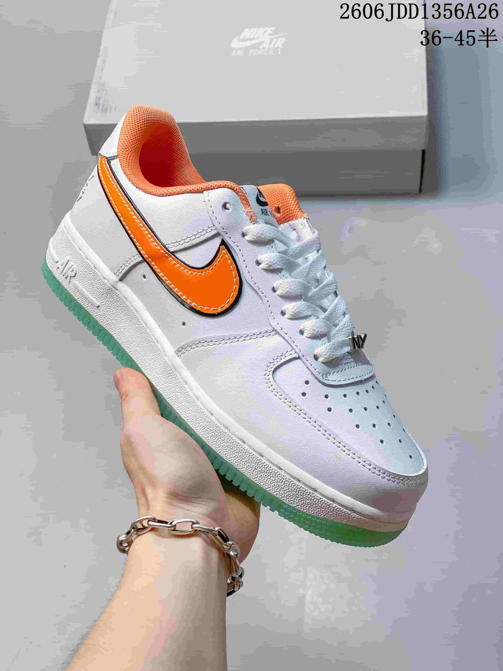 White Nike Air Force 1 low-top sneaker with orange Swoosh and mint outsole