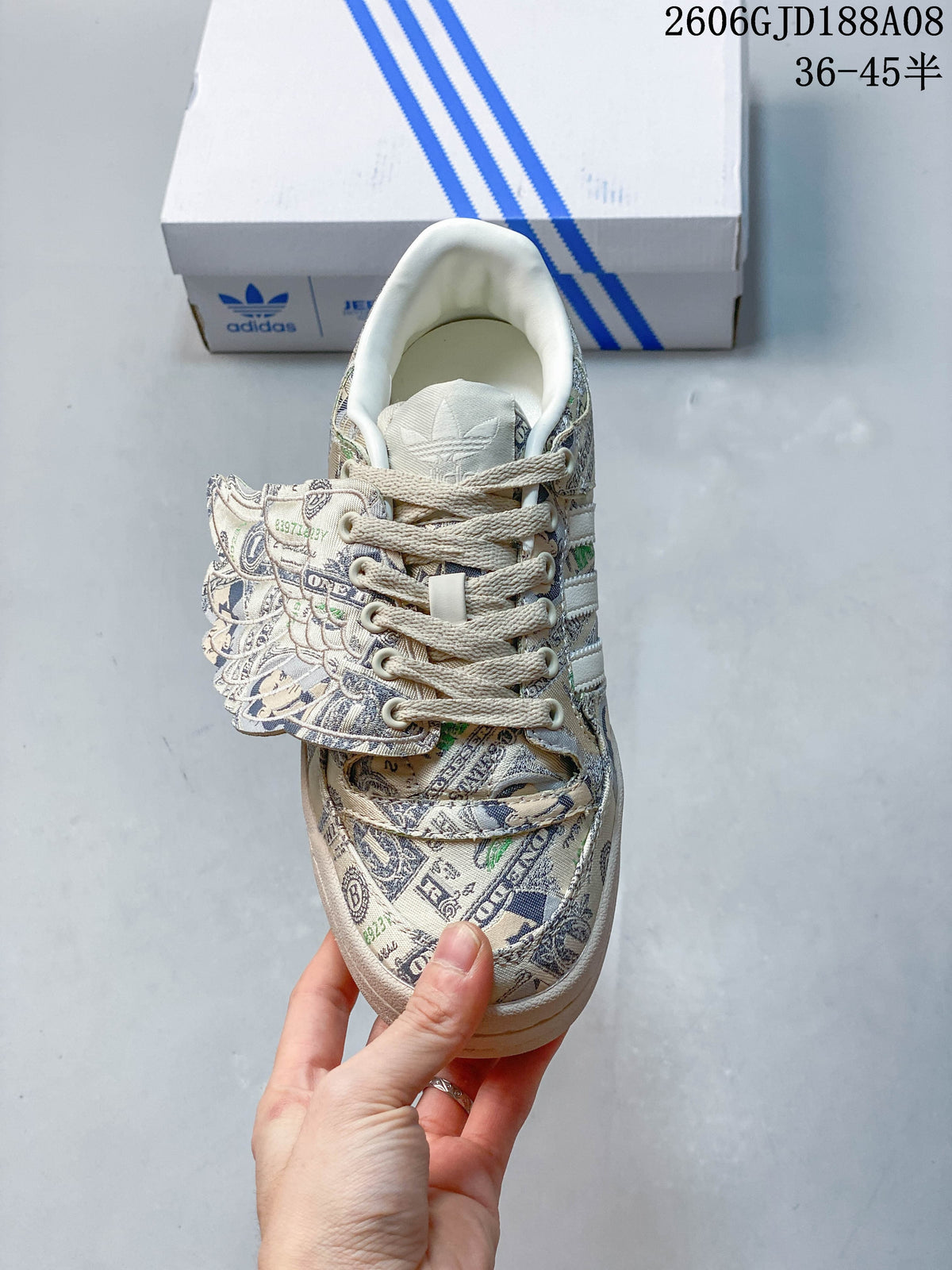 Top view of the sneaker showing cream laces, banknote-print panels and wing detail