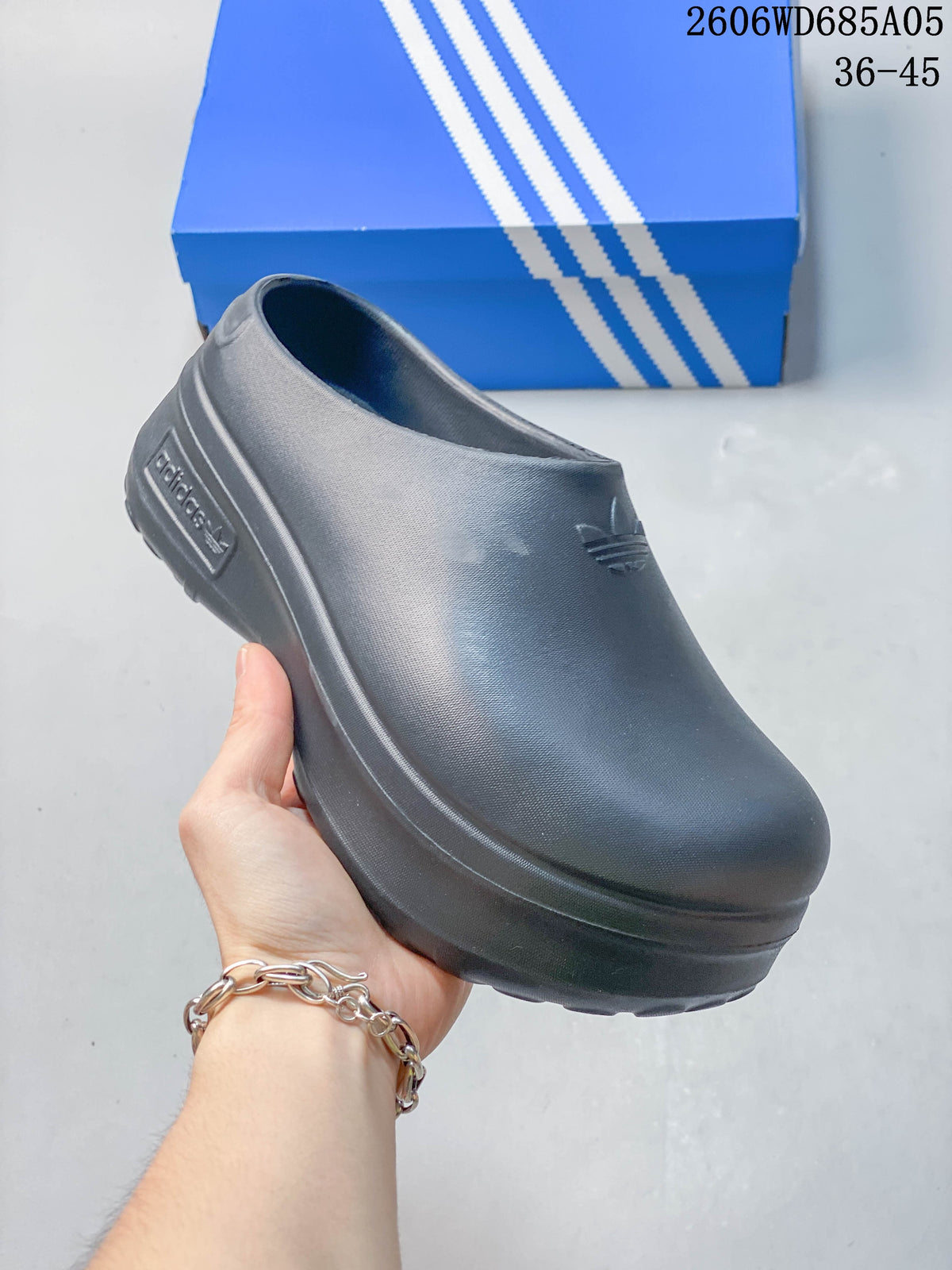 Angled side view of the dark blue-gray mule and its sculpted raised sole
