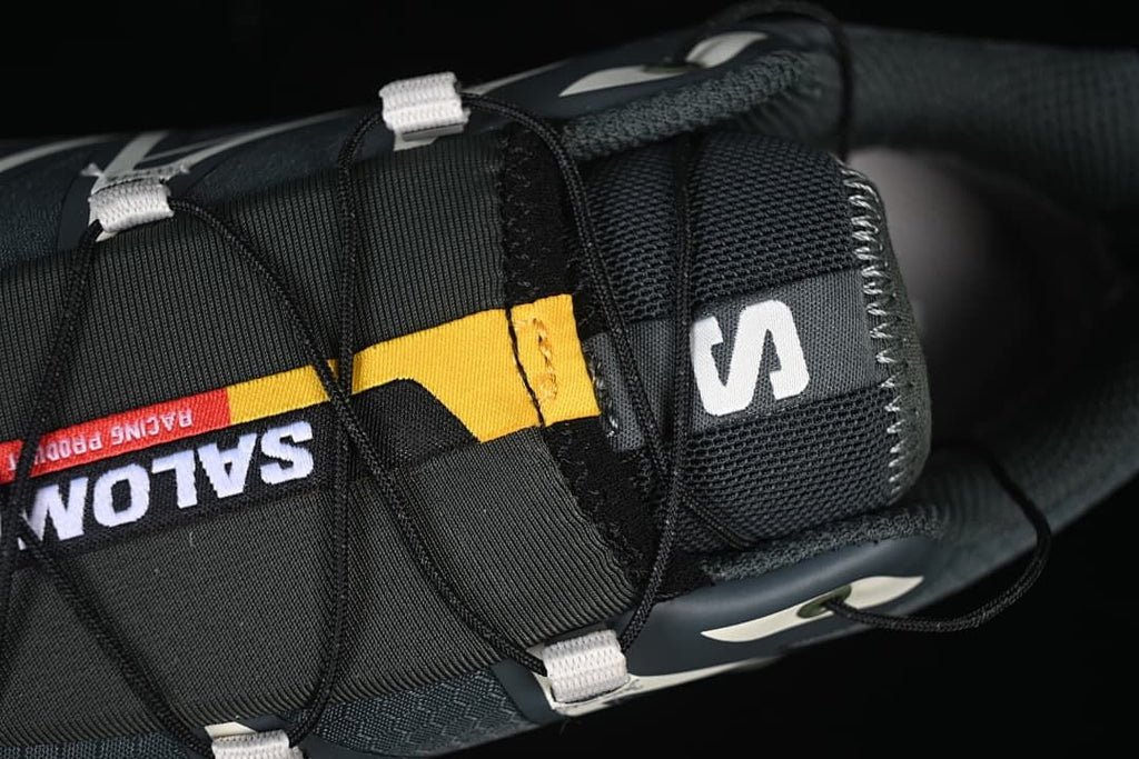 Top close-up of the tongue and lace system with colored Salomon branding.