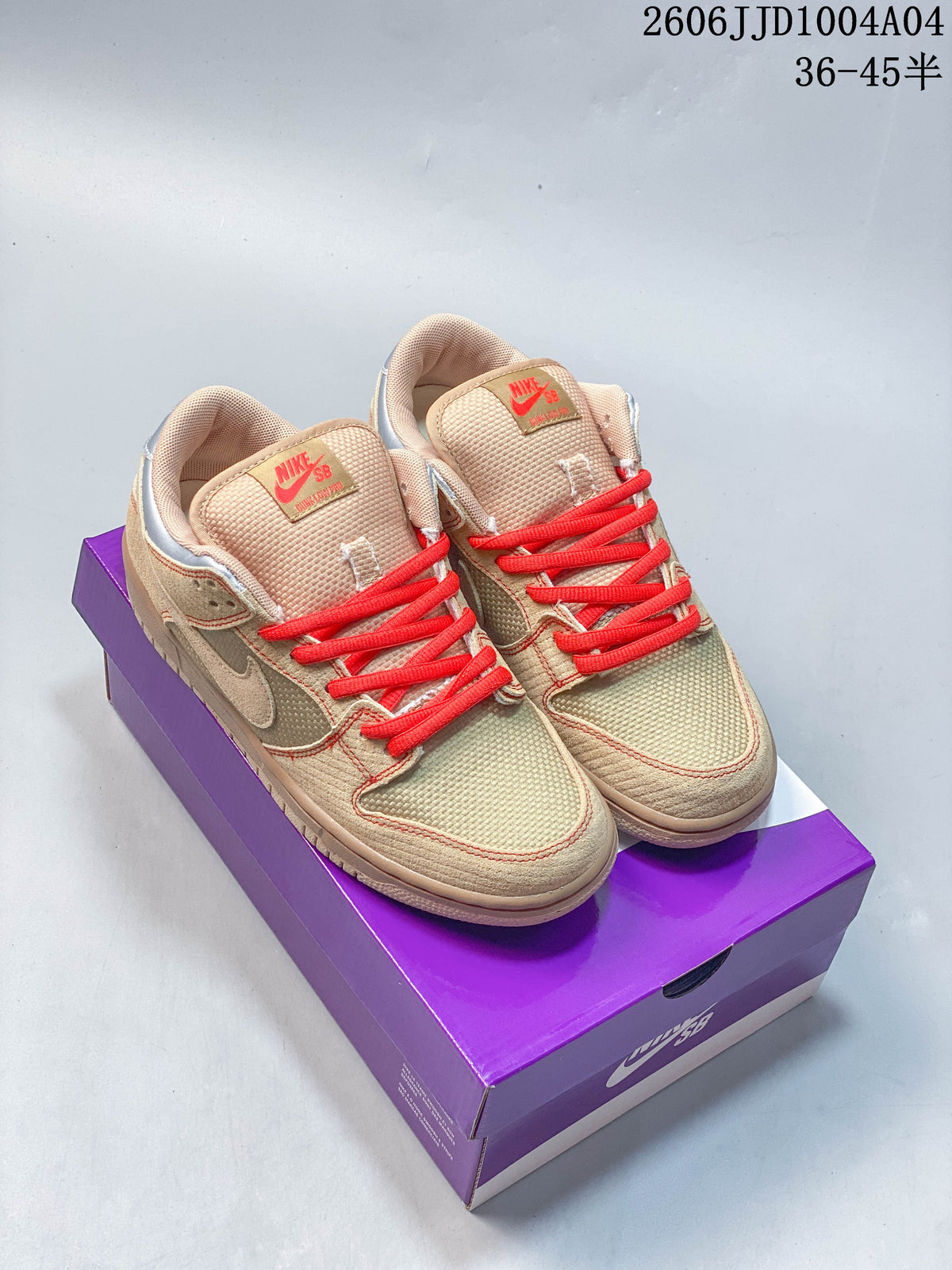 Pair of tan Nike SB Dunk Low Pro shoes with bright red laces on a purple box