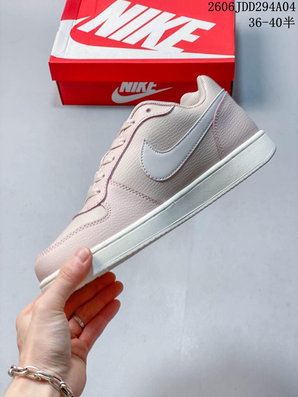 Side view of the pale pink Nike Ebernon Low with a contrasting Swoosh and white sole.