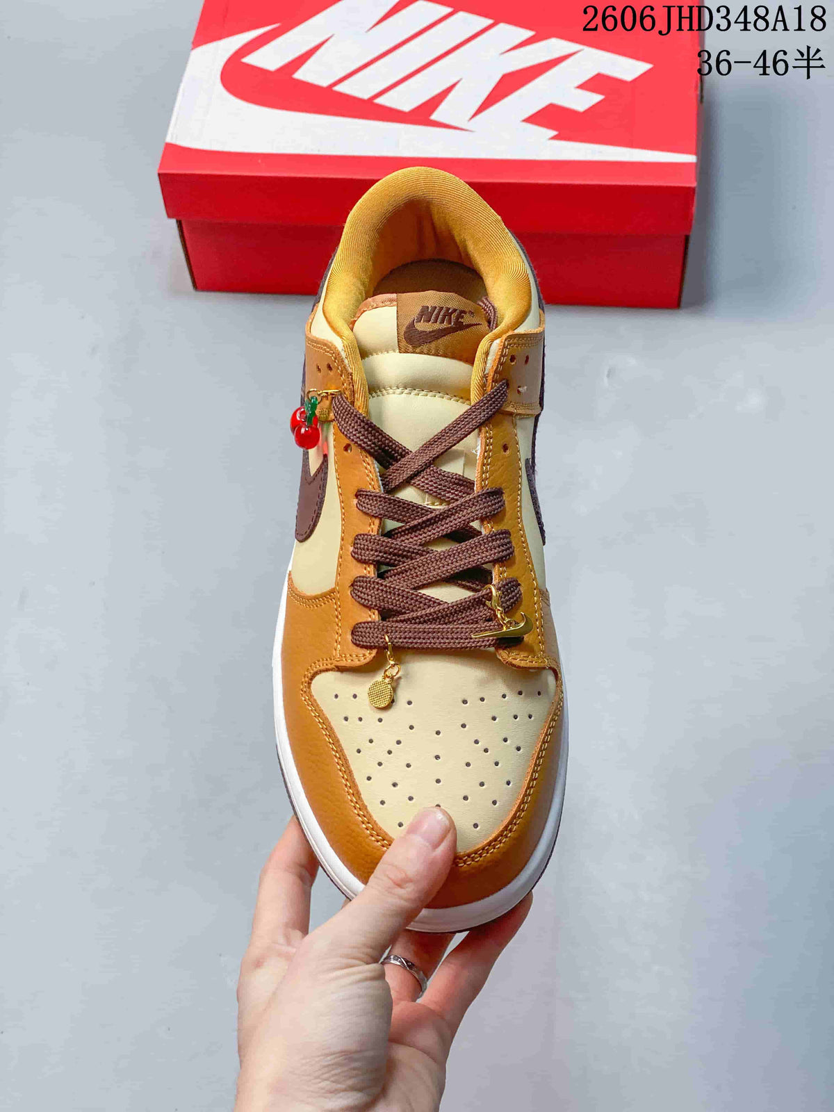 Top view showing the perforated toe, brown laces, and decorative charms.