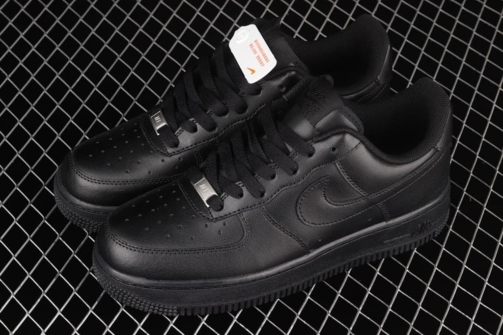 Pair of all-black low-top sneakers shown from above at an angle.