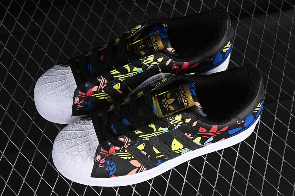 Pair of black graphic Superstar sneakers shown from above