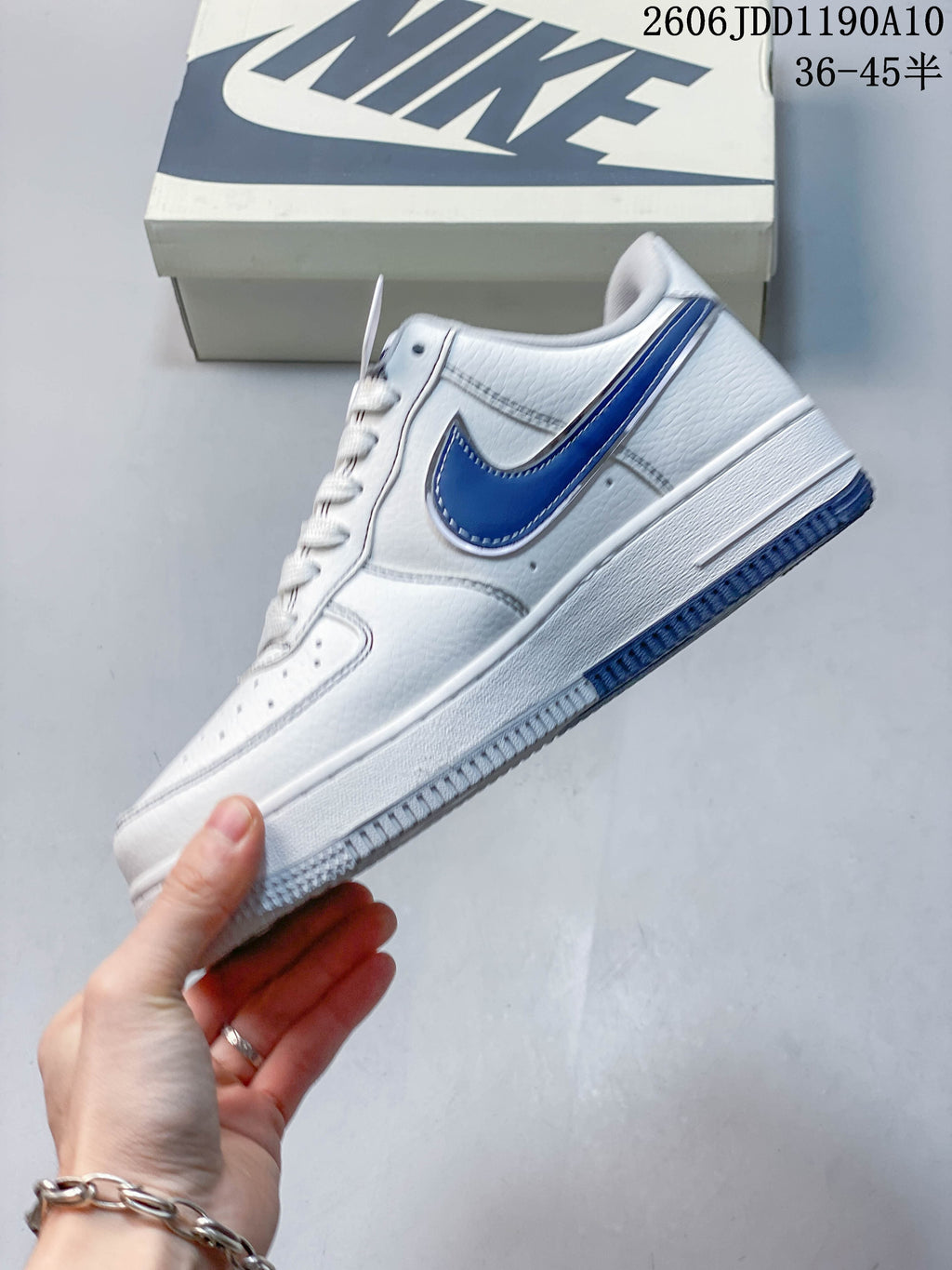 Side view of the white low-top sneaker with a blue Swoosh