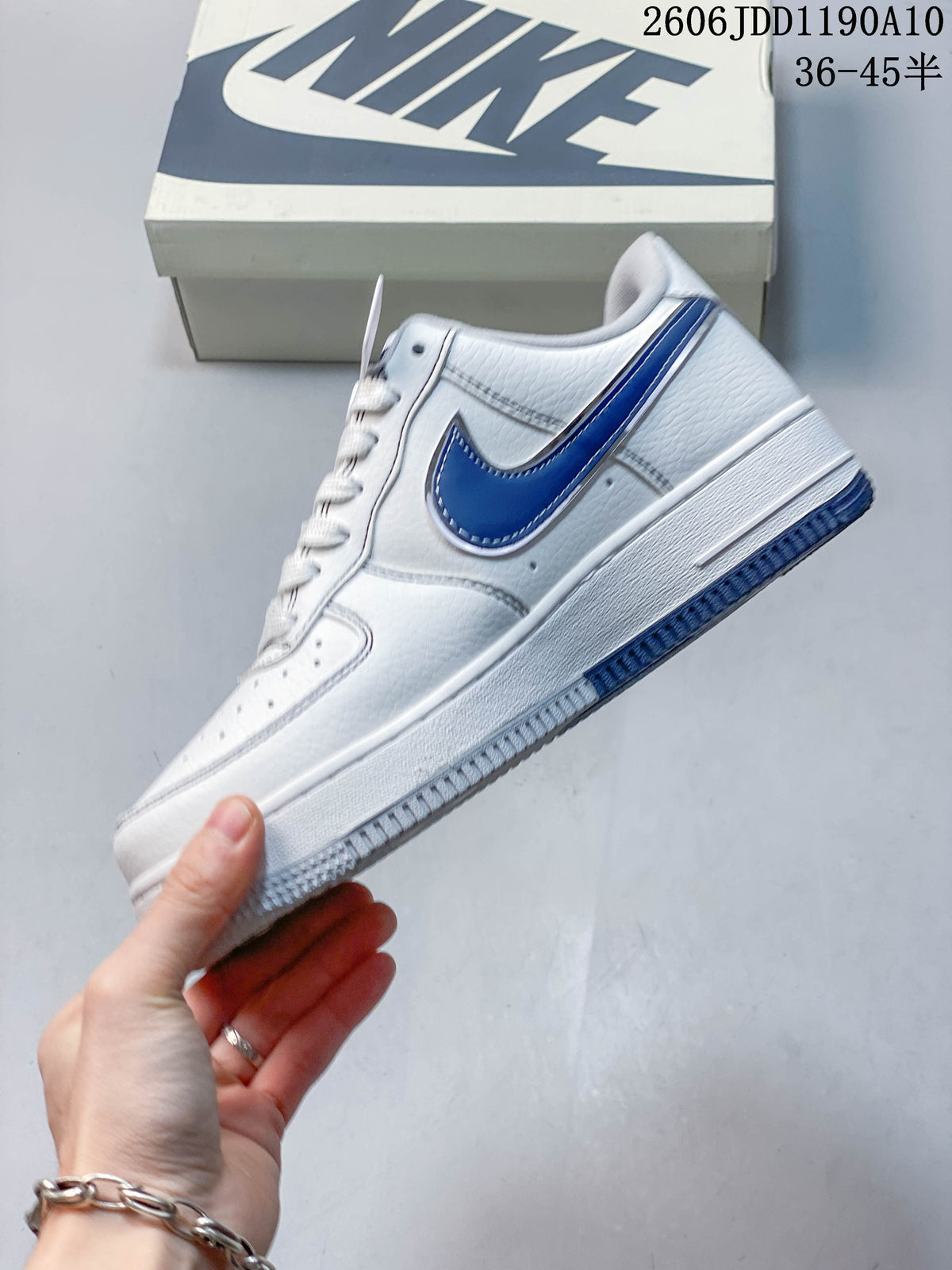 Side view of the white low-top sneaker with a blue Swoosh