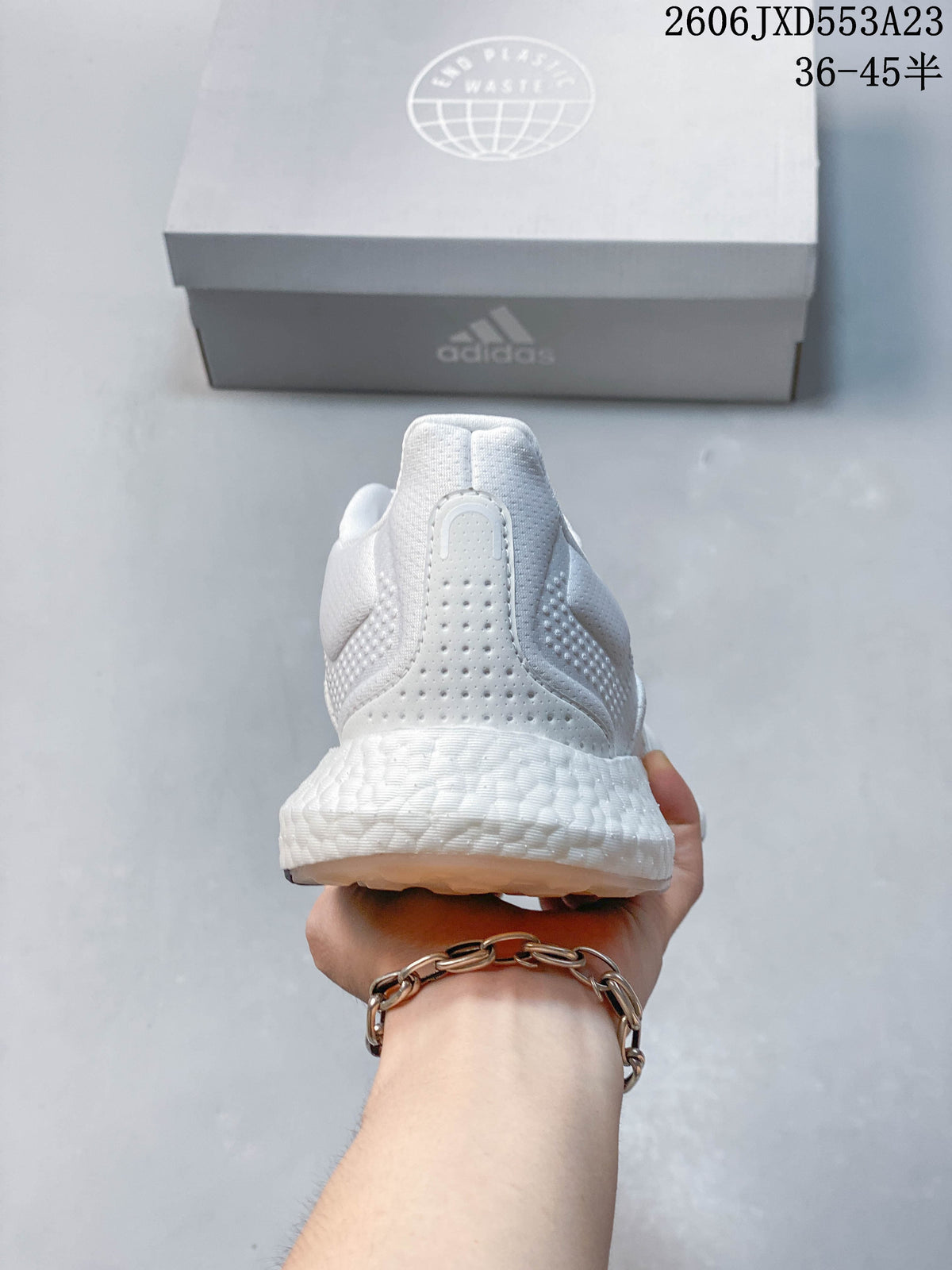 Rear view of a white Adidas PureBoost 21 shoe showing the heel and textured midsole