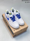 Pair of white Nike Court Vision Low sneakers with blue laces and accents and yellow details, shown on a shoebox.